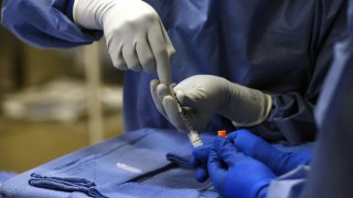 A nurse readies one of eight syringes with stem cells at the University of Maryland.