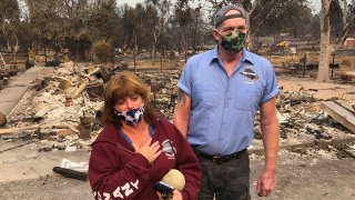 Kevin Conant and his wife, Nikki, look at the debris of their home and business, "Conants Wine Barrel Creations," after the Glass/Shady Fire completely engulfed it, Sept. 30, 2020, in Santa Rosa, Calif.