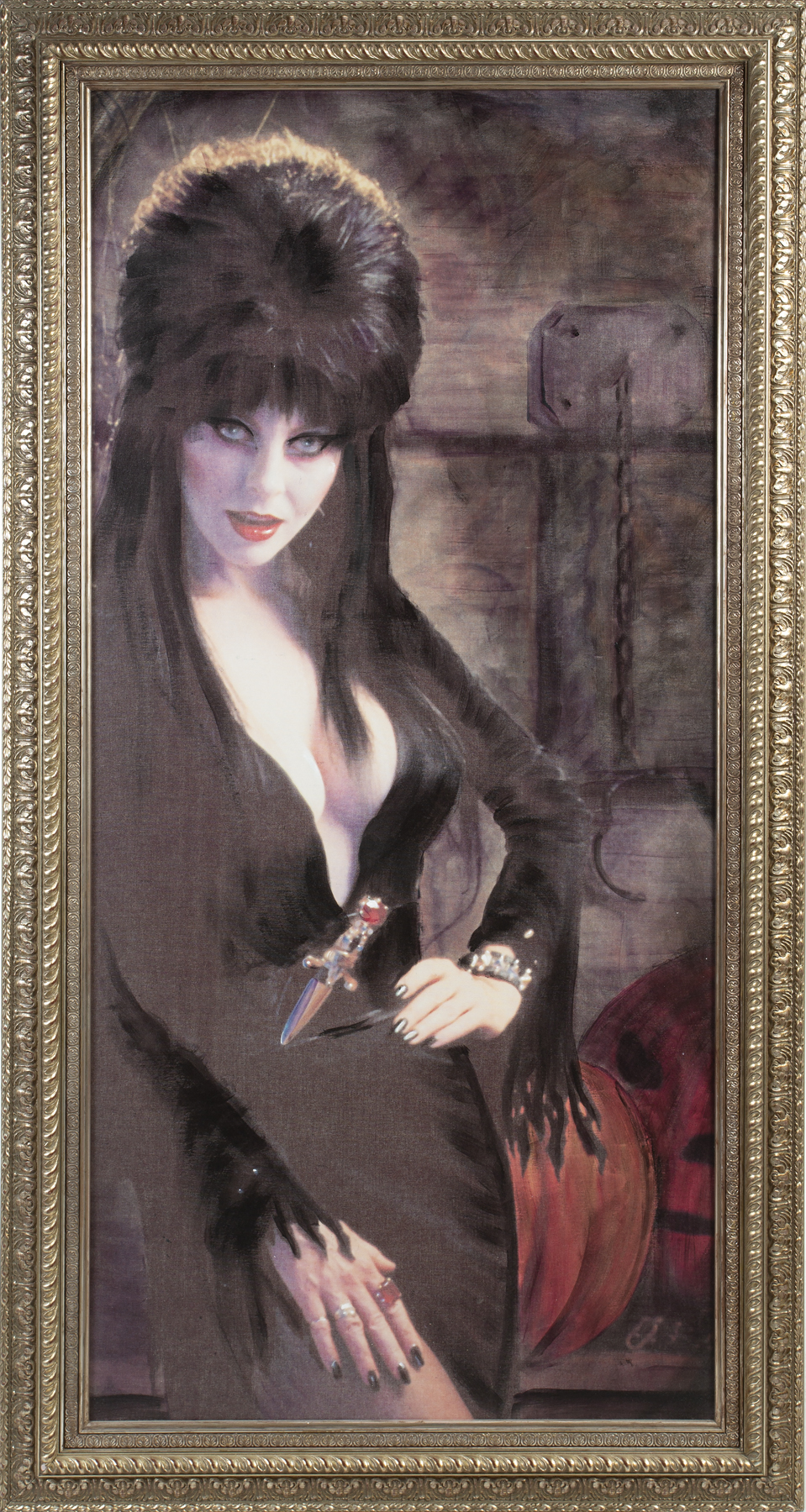 A large giclée work featuring a stunning image of Elvira in an elaborate gilt frame. Created by photographer David Goldner, this piece was used in several film and television productions during 1997 to 2010 including Superstition (Iwerks Entertainment, 1997), The Search for the Next Elvira (Fox Network, 2007-present), Elvira's Movie Macabre (Syndicated Television, 2010-2011), and a Blockbuster Video promo.