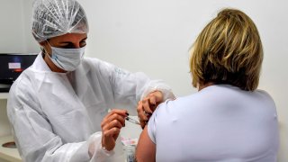 In this July 2020, file photo, a Brazilian doctor voluntarily receives an injection as part of phase 3 trials of a vaccine developed by the University of Oxford and British pharmaceutical company AstraZeneca.