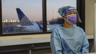 A healthcare worker wears personal protective equipment (PPE) during a United Airlines Covid-19 test pilot program at Newark Liberty International Airport in Newark, New Jersey, U.S., on Monday, Nov. 16, 2020.
