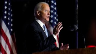 Joe Biden speaks with American flags in background