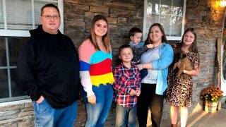 Keith Michael, left, poses with his children, from left, Jessica, Hunter, Houston, Sara and Holly, outside their home on Friday, Nov. 13, 2020, in Jonesboro, Ark.