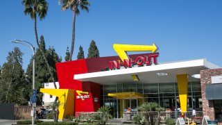 An In-N-Out restaurant in California with palm trees.