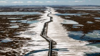 An oil pipeline stretches across the landscape outside Prudhoe Bay in North Slope Borough, Alaska