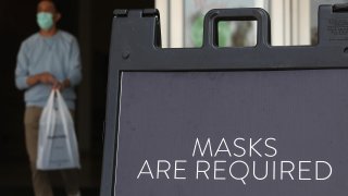 A sign tells customers to wear masks to prevent the spread of COVID-19.