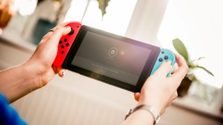 A person holding a Nintendo Switch game console