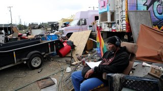 Larry Coke sits in his recliner at the Wood Street encampment in Oakland.