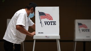 In this Oct. 13, 2020, file photo, a voter fills out his ballot while early voting at the Santa Clara County registrar of voters office in San Jose, California.