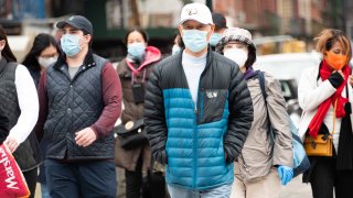 In this Nov. 15, 2020, file photo, people wear face masks in Chinatown as the city continues the re-opening efforts following restrictions imposed to slow the spread of coronavirus in New York City.