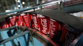 Cans produced for Coca-Cola Co.'s Coke drink move along the production line.