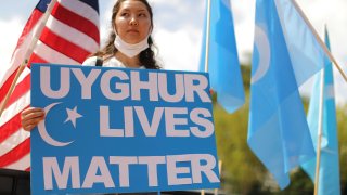 A protester outside the White House urges the United States to take action to stop the oppression of the Uyghur