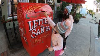 Children drop off letters to Santa at a Burbank coffee shop in Dec. 2020.