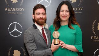 Andy Mills and Rukmini Callimachi pose with the Peabody award