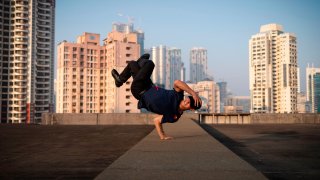 TOPSHOT - Austria's breakdancer Fouad Ambelj aka Lil Zoo, winner of the Red Bull BC One world championship in 2018, dances on a roof during a photo session in Mumbai on November 10, 2019. - The International Olympic Committee (IOC) has chosen to integrate brakdancing into the 2024 Olympic Games in Paris.