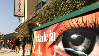 People wait in line for a free COVID19 test in front of a closed Taix French Restaurant in Echo Park.