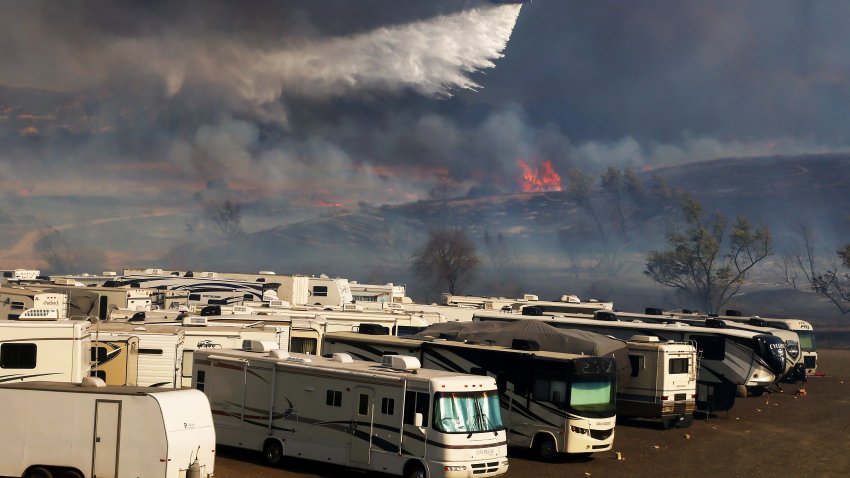 IRVINE CALIFORNIA – DECEMBER 03: A firefighting helicopter drops water over the Bond Fire burning in the Silverado Canyon area of Orange County on December 3, 2020 near Irvine, California. The 4,000-acre wildfire broke out along with a number of other fires in Southern California amid gusty Santa Ana winds in the region.  (Photo by Mario Tama/Getty Images)