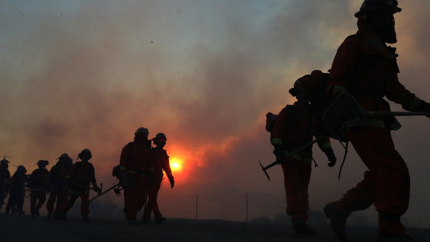 IRVINE CALIFORNIA – DECEMBER 03: Inmate firefighters work as the Bond Fire burns shortly after sunrise in the Silverado Canyon area of Orange County on December 3, 2020 near Irvine, California. The wildfire broke out along with a number of other fires in Southern California amid gusty Santa Ana winds in the region. (Photo by Mario Tama/Getty Images)