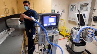 A Respiratory Care Practitioner sets up a ventilator.
