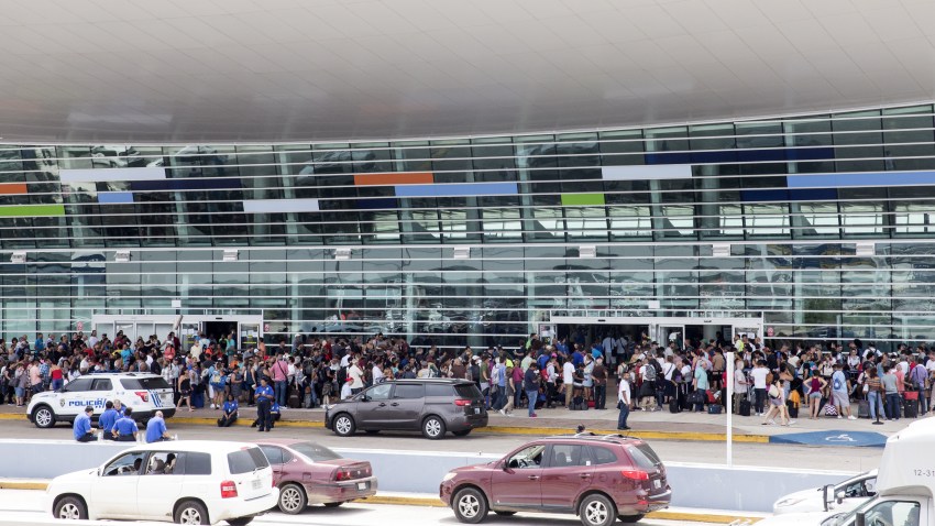 Travelers stand in line outside of Luis Muoz Marn International Airport after Hurricane Maria disrupted flight service in San Juan, Puerto Rico on Wednesday, Sept. 27, 2017. President Donald Trump said he may temporarily suspend a law that restricts the use of foreign ships operating in U.S. waters and between U.S. ports in order to accelerate the delivery of aid to Puerto Rico, where his administration faces mounting criticism over its response to Hurricane Maria.