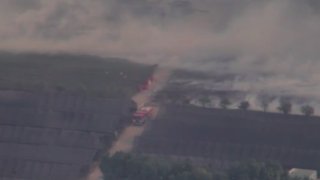 Firefighters battle flames in a field in Santa Paula on Monday, Dec. 7, 2020.