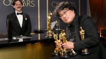 Writer-director Bong Joon-ho, winner of the Best Picture, Director, Original Screenplay, and International Feature Film awards for "Parasite," holds the trophies won by his black comedy flick at the 92nd Academy Awards Governors Ball at Hollywood and Highland on Feb. 9, 2020, in Hollywood, California.