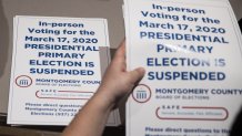 County election workers hand out election delayed signs to put up at polling stations in Dayton, Ohio on March 17, 2020 after the primaries were canceled due to the coronavirus.