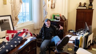 A supporter of US President Donald Trump sits inside the office of US Speaker of the House Nancy Pelosi as he protest inside the US Capitol in Washington, DC, January 6, 2021.