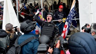 A man calls on people to raid the building as Trump supporters clash with police and security forces as they try to storm the Capital Building in Washington D.C on Jan. 6, 2021.