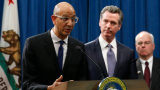 In this March 12, 2020, file photo Dr. Mark Ghaly, secretary of the California Health and Human Services, discusses the coronavirus as Gov. Gavin Newsom, center, listens at a news conference in Sacramento, Calif.