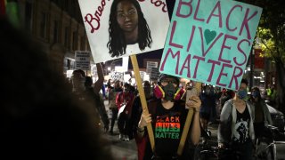 In this Nov. 7, 2020, file photo, a person holds a sign reading "Black Lives Matter" during a rally at Nubian Square in Roxbury