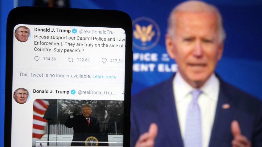 In this photo illustration, Donald Trump Twitter messages are seen displayed on a smartphone screen in front of a fragment of a video with U.S. President-elect Joe Biden addressing Trump supporters as they continue with protests in and near the U.S. Capitol in Washington during the U.S. Congress session to certify the 2020 Presidential election results.