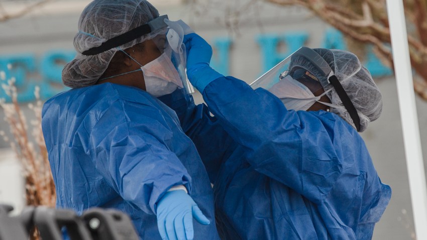 在这张2020年11月23日的档案照片中，在德克萨斯州埃尔帕索县的冠状病毒病（COVID-19）爆发的情况下，埃尔帕索县医学检查官办公室的工作人员将装在标有 'Covid '的袋子里的尸体从冷藏拖车中卷进停尸房办公室。(photo:NBCLA)