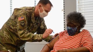 In this Feb. 11, 2021, file photo, Staff Sergeant Herbert Lins of the Missouri Army National Guard administers the COVID-19 vaccine to a resident during a vaccination event at the Jeff Vander Lou Senior living facility in St Louis, Missouri.