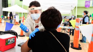 In this Feb. 17, 2021, file photo, Carolyn Fowler of the Los Angeles Unified School District (LAUSD) receives her Covid-19 vaccination at a site opened today by the Los Angeles Unified School District (LAUSD) for LAUSD employees in Los Angeles.