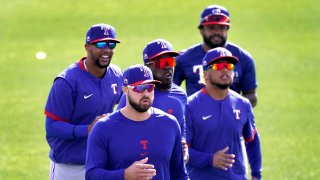 Texas Rangers outfielders from left, Leody Taveras, Joey Gallo, Adolis Garcia, Willie Calhoun and Delino DeShields, back right, run during spring training baseball practice, Friday, Feb. 26, 2021, in Surprise, Ariz.