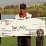 Rookie pro golfer Tiger Woods smiles after receiving a check and trophy for winning the Las Vegas Invitational Sunday, Oct. 6, 1996, at the TPC at Summerlin in Las Vegas.