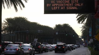 A sign displays directions to a COVID-19 mass vaccination site.