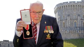 FILE - In this July 17, 2020 file photo, Captain Sir Thomas Moore poses for the media after receiving his knighthood from Britain's Queen Elizabeth, during a ceremony at Windsor Castle in Windsor, England.
