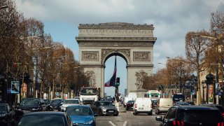 Traffic passes along the Champs Elysee avenue near the Arc de Triomph in Paris, France, on Friday, March 19, 2021. French President Emmanuel Macron is locking down several regions including the Paris area, slowing down the countrys economic recovery as it struggles to contain a third wave of the coronavirus epidemic. Photographer: Cyril Marcilhacy/Bloomberg via Getty Images
