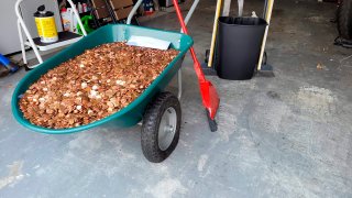 This image provided by Olivia Oxley shows a wheelbarrow filled with pennies, March 20, 2021 in Fayetteville, Ga. A Georgia man said his former employer owed him a pretty penny, $915 to be exact, after leaving his job in November. But Andreas Flaten said he was shocked to see his final payment: 90,000 oil or grease covered pennies, at the end of his driveway earlier this month, news outlets reported. Atop the pile was an envelope with Flaten's final paystub and an explicit parting message.