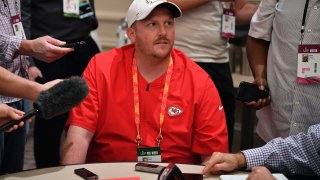 Britt Reid surrounded by reporters during a media session.