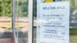 business reopening sign posted amid covid-19 pandemic in storefront window