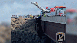 This image provided by the Idaho State Police shows the scene where authorities say a set of camp trailer safety chains and quick, careful work by emergency crews saved two people after their pickup truck plunged off a bridge, leaving them dangling above a deep gorge in southern Idaho on Monday, March 15, 2021.