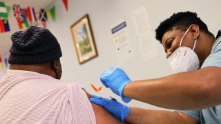 Larry Wiggins is given the Moderna coronavirus (COVID-19) vaccine by Anya Harris at Red Hook Neighborhood Senior Center in the Red Hood neighborhood of the Brooklyn borough on February 22, 2021 in New York City.