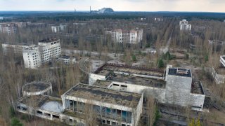 A view of the ghost town of Pripyat with a shelter covering the exploded reactor at the Chernobyl nuclear plant in the background, Ukraine, April 15, 2021. The vast and empty Chernobyl Exclusion Zone around the site of the world’s worst nuclear accident is a baleful monument to human mistakes. Yet 35 years after a power plant reactor exploded, Ukrainians also look to it for inspiration, solace and income.