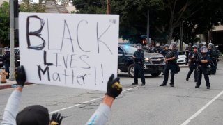 A person holds a Black Lives Matter sign during protests in Los Angeles.