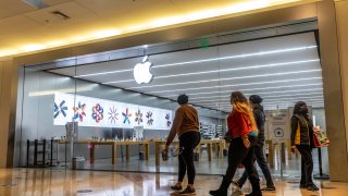 Shoppers walk past an Apple Store at Franklin Park Mall during Black Friday. Shoppers go to stores to take advantage of Black Friday sales during the COVID-19 pandemic.
