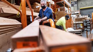 A customer wearing a protective mask loads lumber onto a cart at a Home Depot store in Pleasanton, California, on Monday, Feb. 22, 2021.