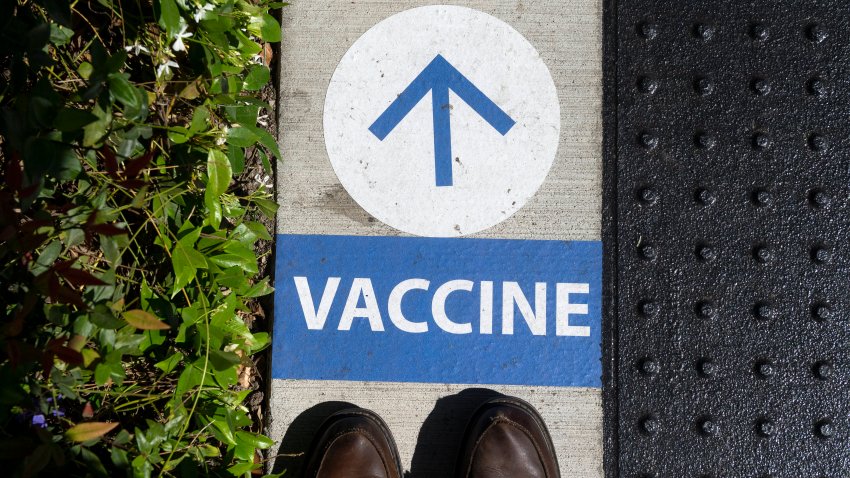 A sign on the ground directs people to get their COVID-19 vaccine at UCI Health Family Health Center in Anaheim, CA on Wednesday, April 28, 2021.